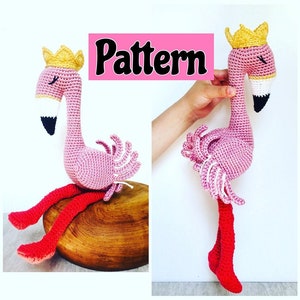 Puede incluir: Un flamenco de crochet rosa con una corona amarilla y patas rojas. El flamenco está sentado sobre una superficie de madera. La palabra "Pattern" está escrita en letras negras sobre un fondo rosa.