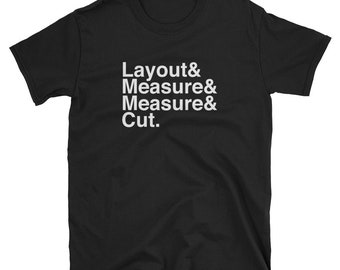 May include: Black t-shirt with white text that reads "Layout & Measure & Measure & Cut."