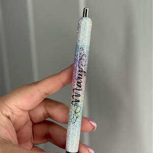 Op de afbeelding: Een glinsterende regenboogkleurige pen met een zwarte inscriptie die "So many SOS" luidt.