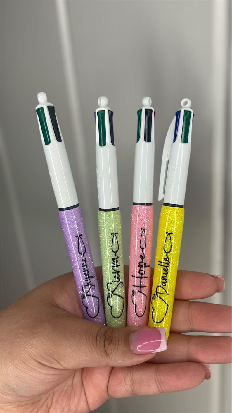 May include: Four multi-colored pens with glitter accents. The pens are labeled "Stephanie", "Sierra", "Hope", and "Danielle".