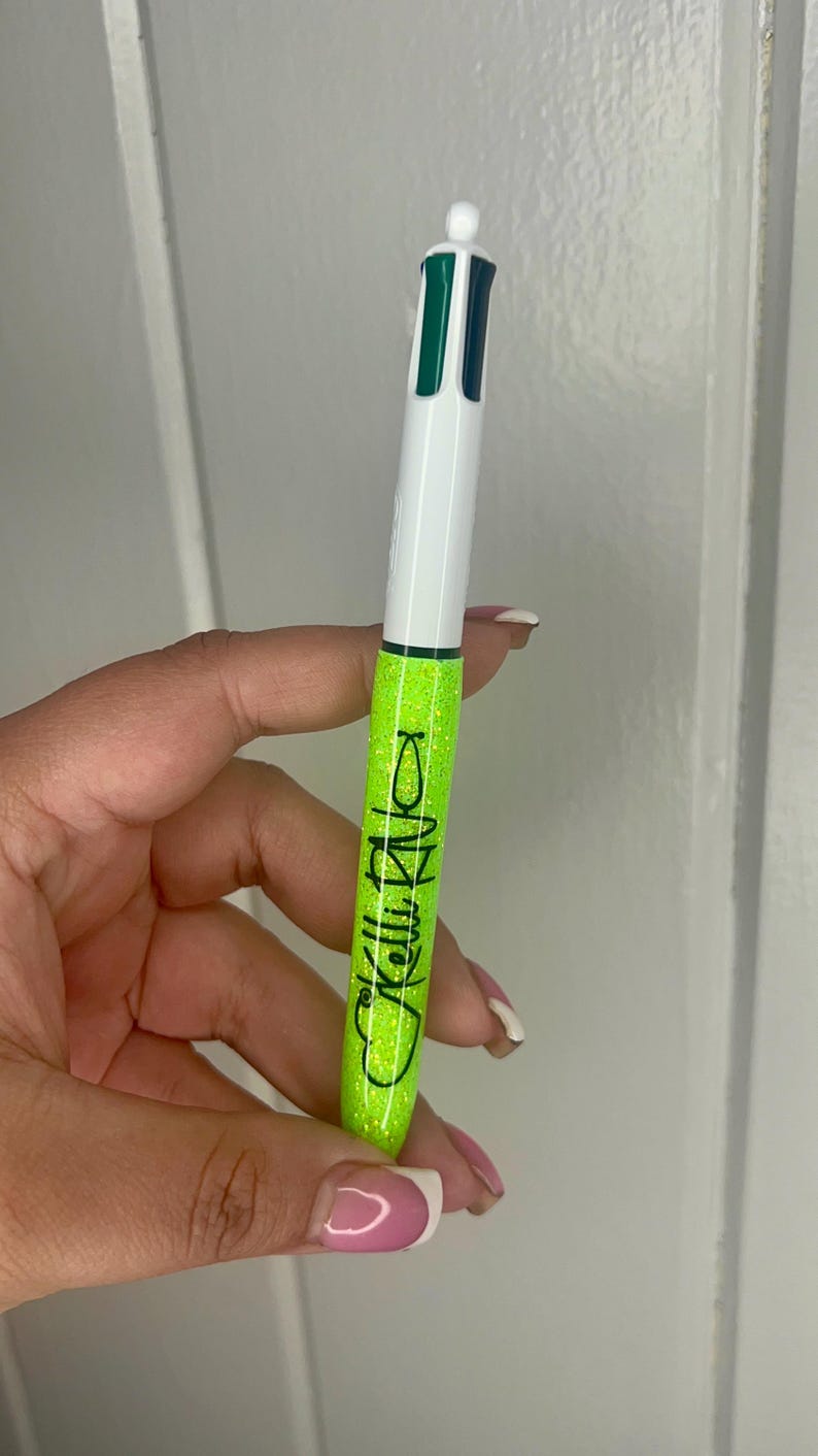 May include: A green and white glitter pen with the text "Kelly Rizzo" written on the side.