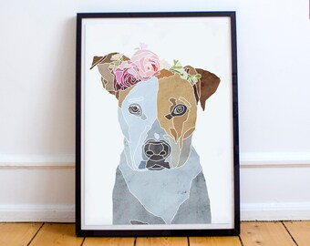 May include: A framed print of a dog wearing a flower crown. The dog is a white and brown pit bull terrier with a blue and gray watercolor background. The print is in a black frame.