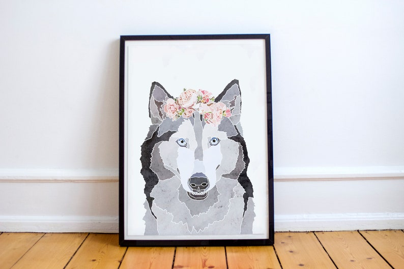 May include: A framed watercolor painting of a wolf wearing a pink flower crown. The wolf has blue eyes and a gray and black coat.