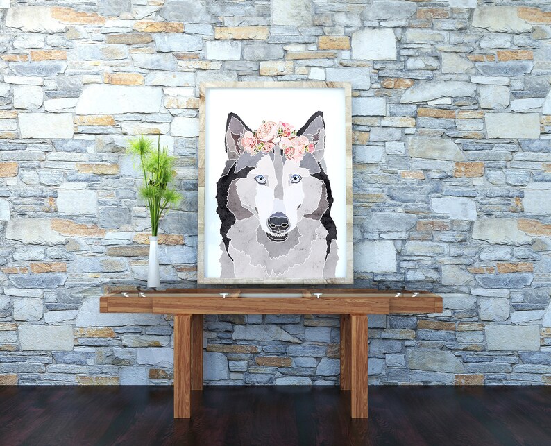 May include: A framed print of a wolf wearing a pink flower crown. The wolf is looking directly at the viewer. The background is a stone wall.