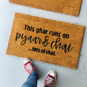Puede incluir: Una alfombra de coco marr&oacute;n con el texto "This ghar runs on pyaar & chai...lots of chai."