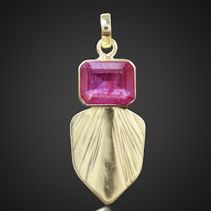 Könnte beinhalten: Ein goldener Anhänger mit einem rosafarbenen Edelstein, der in einer quadratischen Form gefasst ist. Der Anhänger ist an einer goldenen Kette befestigt.