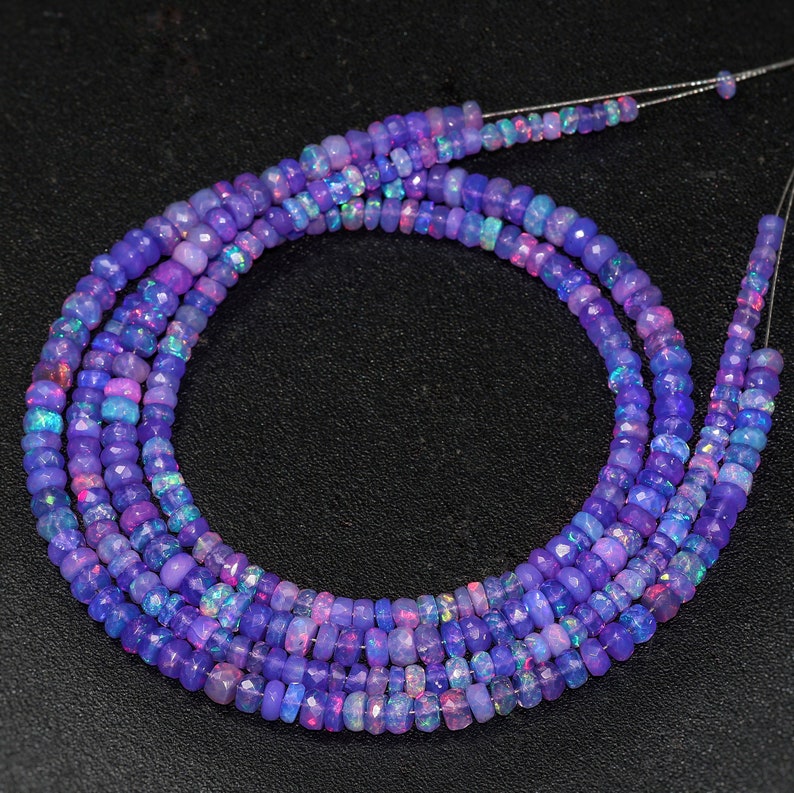 May include: A strand of purple and pink opal beads. The beads are faceted and have a shimmering iridescent finish.