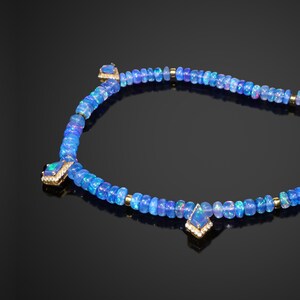 May include: A blue opal necklace with three larger opal pendants set in gold. The necklace is made of small blue opal beads and gold beads.