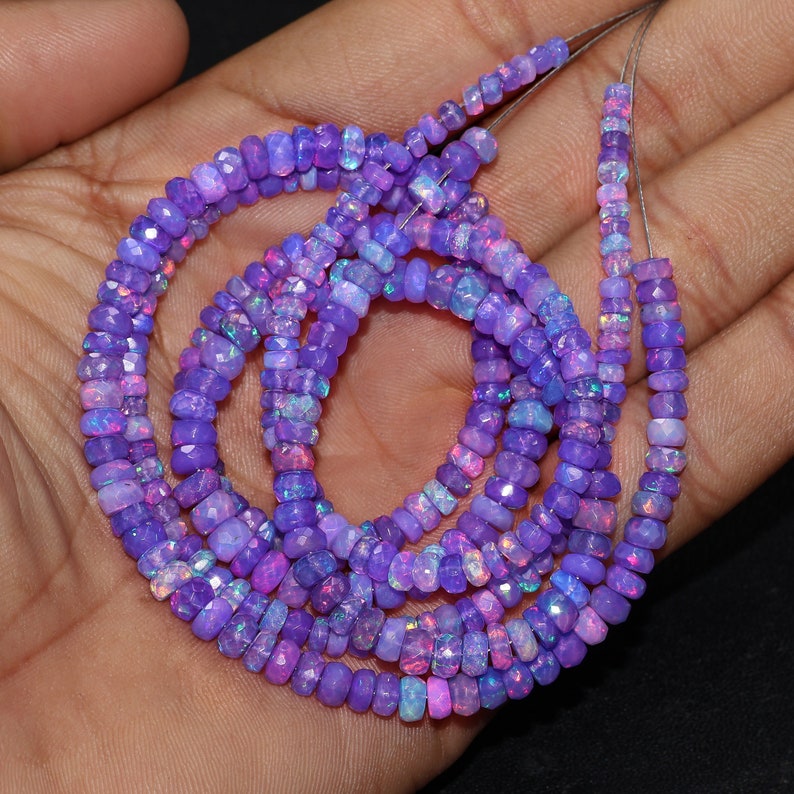 May include: A strand of purple and pink opal beads, with a faceted, square shape. The beads are strung on a thin wire and are approximately 4mm in size.