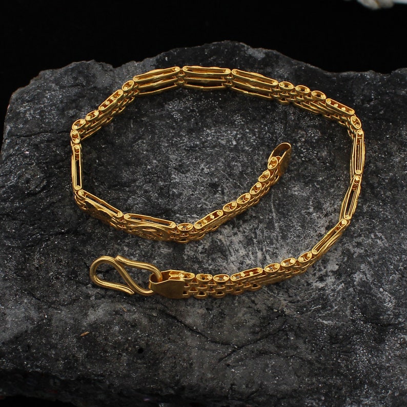 May include: A gold chain bracelet with a box chain design. The bracelet has a lobster clasp closure.