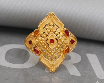 May include: A gold ring with a diamond-shaped design and red stones. The ring is intricately detailed with small beads and filigree work.