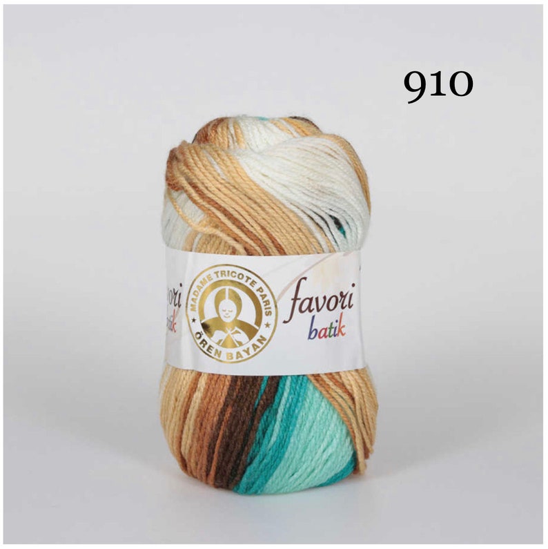 Puede incluir: Ovillo de lana jaspeada en tonos marrones, blancos y turquesas. La etiqueta dice "favori batik" y "MADAME TRICOTE PARIS". El n&uacute;mero "910" est&aacute; impreso en negro. Ideal para proyectos de punto y ganchillo.