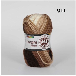 Puede incluir: Ovillo de lana multicolor con tonos marrones, beige y crema. La etiqueta dice "FAVORI Batik" y "911". La lana es de "MADAME TRICOTE PARIS".