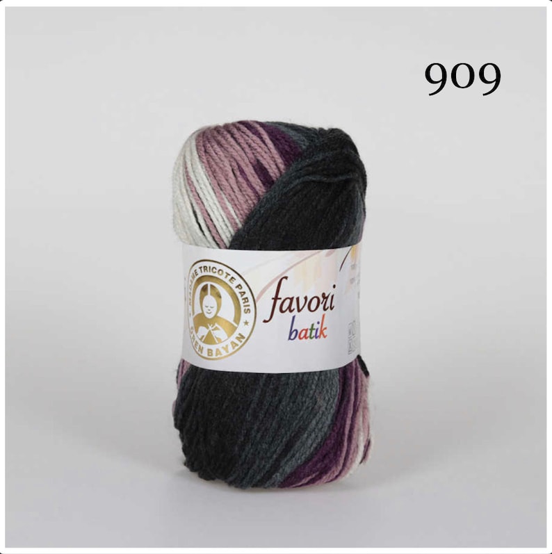 Puede incluir: Un ovillo de hilo Favori Batik en tonos grises, morados, blancos y malva. El hilo est&aacute; envuelto con una etiqueta que incluye el texto "Favori Batik" y un logotipo. El n&uacute;mero "909" es visible en la esquina superior derecha.