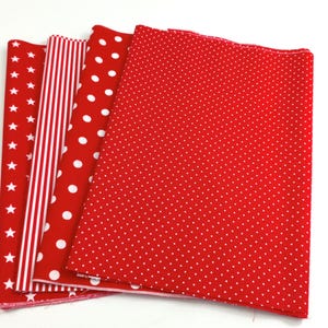 Könnte beinhalten: Eine Sammlung von vier rechteckigen Stoffstücken mit rot-weißen Mustern. Die Designs umfassen weiße Sterne auf Rot, vertikale rot-weiße Streifen, große weiße Punkte auf Rot und ein feines weißes Mikro-Punktmuster auf rotem Untergrund.