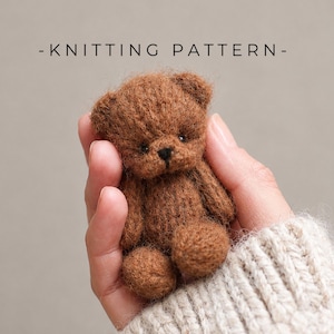 May include: A miniature brown teddy bear made of fuzzy yarn with small dark eyes and a stitched nose. The text - KNITTING PATTERN - is displayed above the bear. The bear is small enough to be held in the palm of a hand.