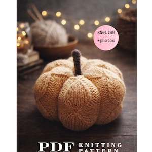 May include: A tan knitted pumpkin with a dark brown stem, featuring a textured diamond pattern. The image includes a pink circular label with the text ENGLISH +photos and white text at the bottom reading PDF KNITTING PATTERN.