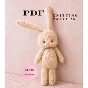 Op de afbeelding: Een gebreid konijn van beige garen staat op een roze ondergrond. De afbeelding bevat de tekst "PDF Knitting Pattern" en "English + photos". Het konijn heeft lange oren, kleine armen en benen.
