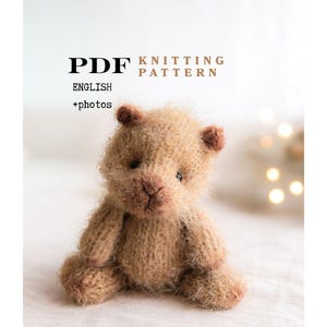May include: A knitted teddy bear in light brown, with a fluffy texture, sitting on a white surface. The bear has small, dark brown ears and a detailed nose. Text on the image reads "PDF KNITTING PATTERN ENGLISH +photos".