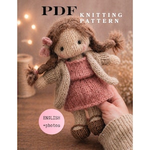 Op de afbeelding: Een PDF-breipatroon voor een gebreide pop. De pop heeft bruin haar, een roze jurk en een beige vest. De tekst "ENGLISH + photos" staat in een roze cirkel. De tekst "PDF KNITTING PATTERN" staat bovenaan.