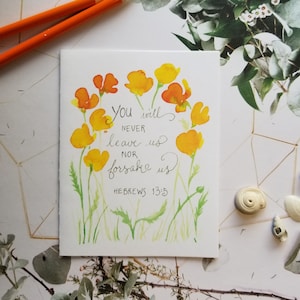 May include: Watercolor art print featuring yellow and orange flowers surrounding the text "You will never leave us nor forsake us" from Hebrews 13:5. The artwork has a soft, painterly style with green stems and leaves.