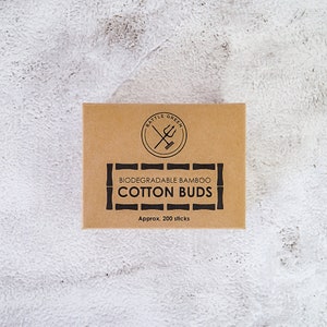 May include: A brown cardboard box with the text "BATTLE GREEN" in a circle with a crossed sword and trident inside. The box also says "BIODEGRADABLE BAMBOO COTTON BUDS" and "Approx. 200 sticks".