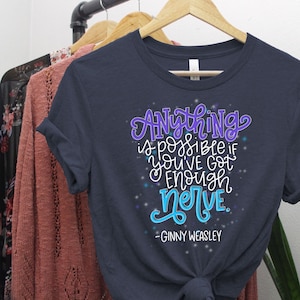 May include: Navy blue t-shirt with a white and blue graphic print that says "Anything is possible if you've got enough nerve." The quote is attributed to Ginny Weasley.