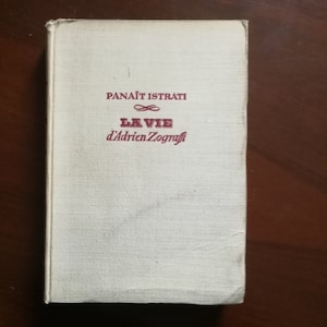 May include: A white book with a red title that reads "Panaït Istrati" and "La Vie d'Adrien Zograffi".