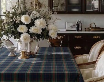 May include: A dining room table set with a navy blue, green, and red plaid tablecloth. The table is set with a floral centerpiece and elegant chairs. A crystal chandelier hangs above the table, and a dark wood cabinet is in the background.
