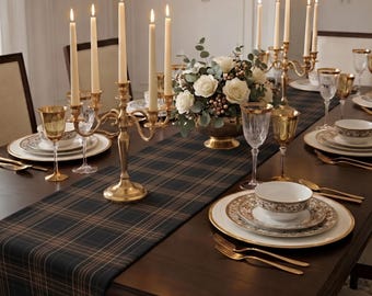 May include: A formal dining table setting featuring a dark green and brown plaid table runner, gold candelabras with cream taper candles, white floral centerpieces, gold-rimmed plates, patterned bowls, and gold-toned cutlery and glassware.