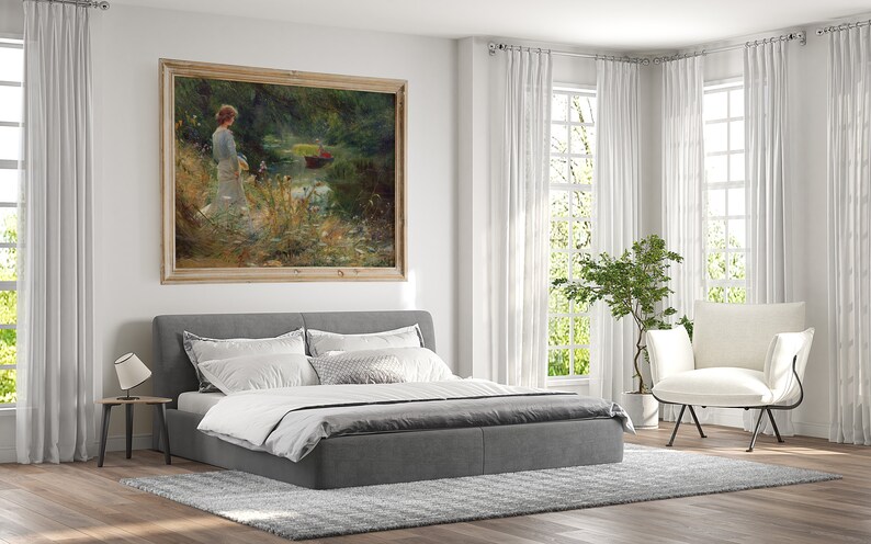 Peut inclure: Un lit rembourr&eacute; gris avec une literie blanche et un tableau encadr&eacute; d'une femme debout dans une for&ecirc;t au bord d'un lac. Le tableau est dans un cadre en bois clair. Le lit est dans une chambre avec des rideaux blancs et un fauteuil blanc.
