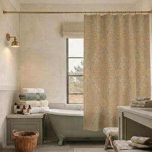 May include: A bathroom scene featuring a beige floral patterned shower curtain, a clawfoot bathtub, and a stack of folded towels. A gold-toned shower rod and wall sconce add to the room's aesthetic. A wicker basket sits on the floor.