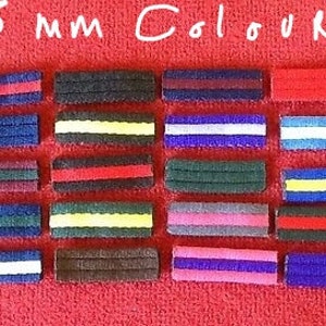 May include: Twenty-five 25 mm color ribbon strips. The strips are arranged in rows of five, with each row featuring a different color combination. The colors include red, white, blue, yellow, black, brown, gray, and pink.