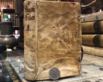 May include: A vintage book with a leather cover. The book is bound in brown leather and has a title on the spine that reads "Bem Fido".