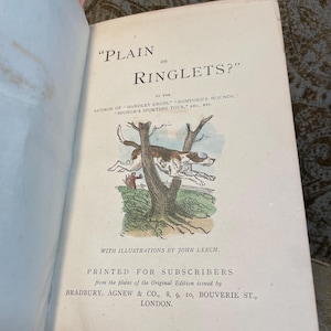 May include: A vintage book cover with the title "Plain or Ringlets?" by the author of "Handley Cross", "Romford's Hounds", "Sponge's Sporting Tour", etc. The cover features a black and white illustration of a dog jumping over a tree branch.
