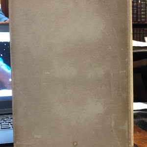 Pu&ograve; includere: La copertina posteriore di un libro rilegato con una copertina liscia di colore avorio. La copertina presenta alcune piccole macchie scure.
