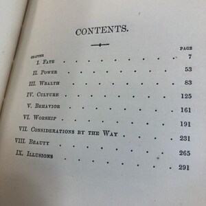 May include: An open book page with the heading "CONTENTS." The table of contents lists chapters such as "FATE," "POWER," and "WEALTH," with corresponding page numbers. The text is in black font on a cream-colored paper.