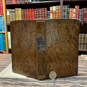 May include: A brown leather-bound book with gold accents and the title "Oeuvres de Poesias" on the spine.