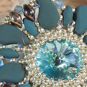 Puede incluir: Pendientes de cuentas azul teal y plata con una gran piedra turquesa en el centro.