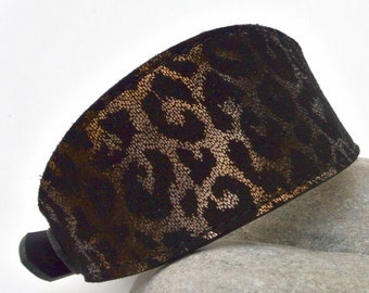 May include: A black and gold leopard print collar with a black buckle.