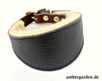 May include: A dark brown leather collar with a textured surface and a cream-colored faux fur lining. The collar features a metal buckle, silver-toned rivets, and a D-ring for attachment. The text ambergarden.de is visible in the bottom right corner.