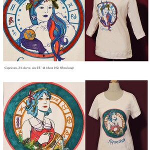 Puede incluir: Camisetas blancas con dise&ntilde;os de zodiaco pintados a mano. Una camiseta presenta una ilustraci&oacute;n de Capricornio con detalles azules y rojos, y la otra muestra un dise&ntilde;o de Acuario. Las camisetas se exhiben en maniqu&iacute;es.