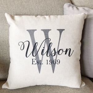 May include: A white throw pillow with a large black letter "W" and the text "Wilson Est. 1969" in black.