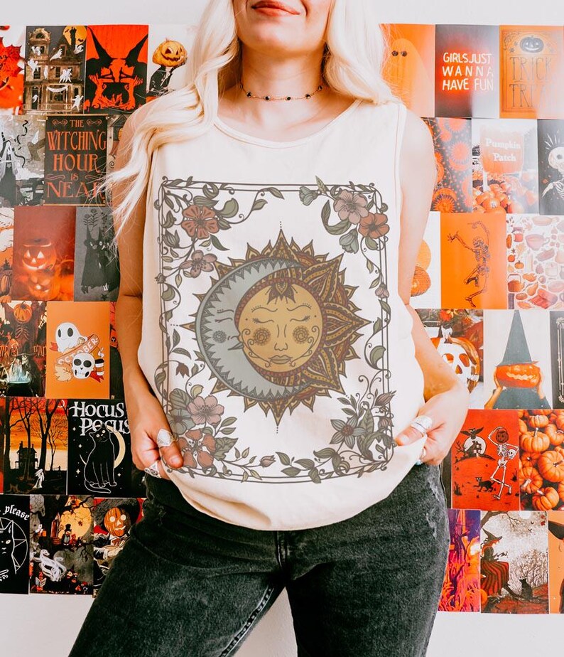 Op de afbeelding: Cr&egrave;mekleurige tanktop met een zon- en maanontwerp met bloemaccenten. De afbeelding is omlijst door een bloemenrand. De achtergrond is een collage van Halloween-posters.