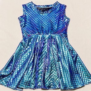 May include: A sleeveless blue and green iridescent dress with a mermaid scale pattern. The dress has a fitted bodice and a flared skirt.