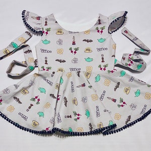 May include: A grey sleeveless dress with a black trim and a white background. The dress is covered in a pattern of The Office characters and objects, including the words "The Office" and "Office".
