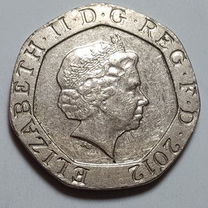 Może przedstawiać: Srebrna brytyjska moneta dwufuntowa z profilem królowej Elżbiety II i napisem "ELIZABETH II D.G. REG. F.D. 2012".