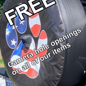 May include: Black spare tire cover with a red, white, and blue paw print design. The text "FREE Camera hole openings on all of our items" is printed on the cover.