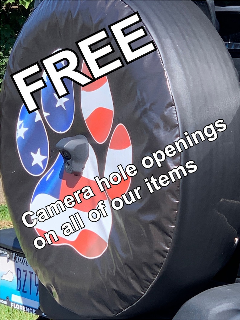 May include: Black spare tire cover with a red, white, and blue paw print design. The text "FREE Camera hole openings on all of our items" is printed on the cover.