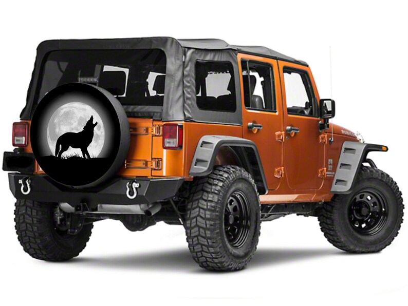 May include: A black spare tire cover with a silhouette of a wolf howling at the moon. The cover is on a orange Jeep Wrangler.